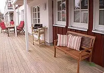 Überdachte Terrasse der Ferienwohnung Deichkieker in Greetsiel mit Holzbank und Gartenmöbeln